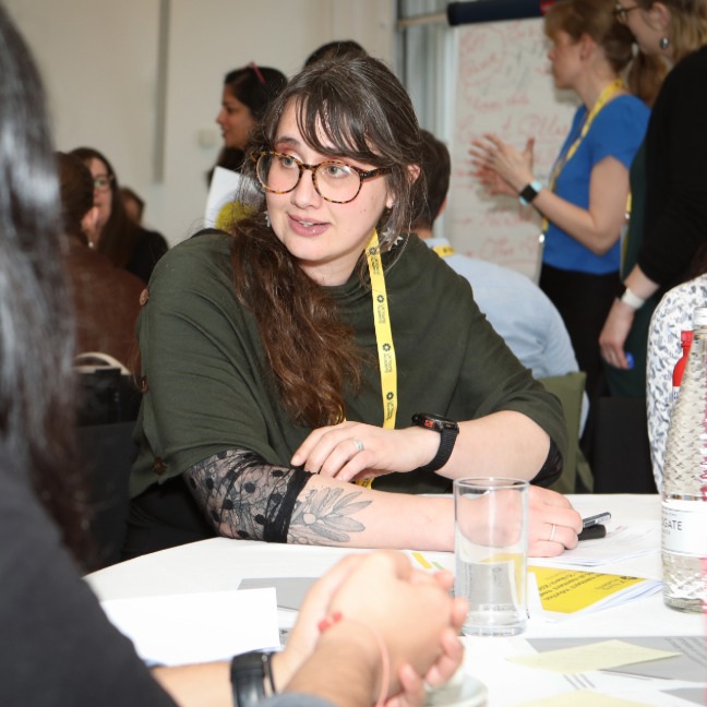 Woman smiles at others during a conference