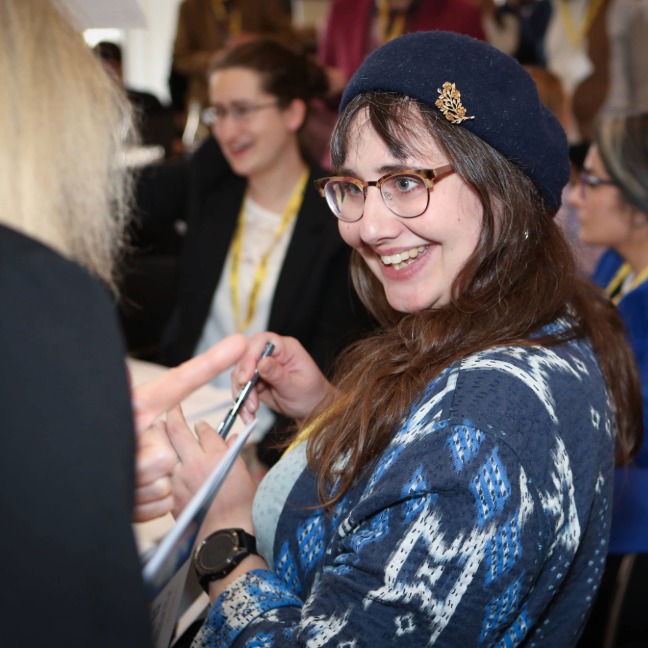 Woman smiles at others during a conference