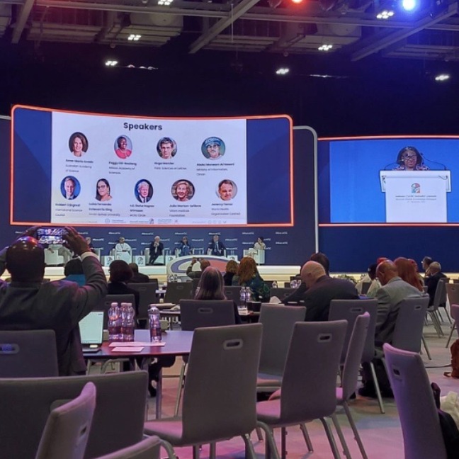 Conference room with chairs and people facing the stage.