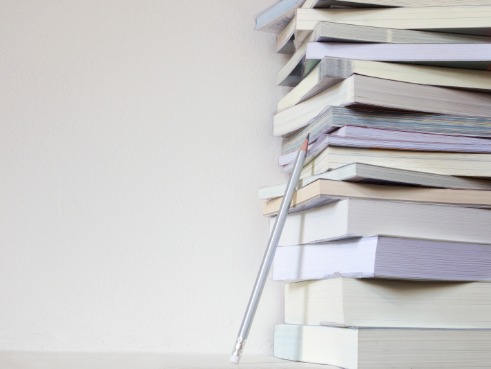 Stack of books with a pencil leaning against it