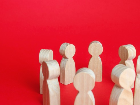 Group of wooden human figures gather in a circle