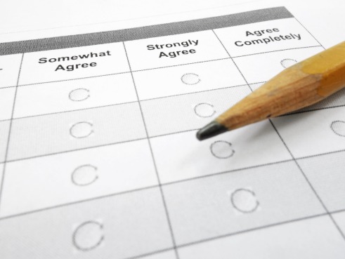 Someone completes a survey on a clipboard