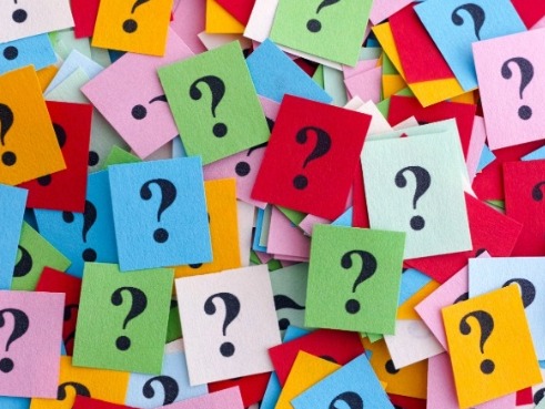 Multicoloured bits of paper with a question mark written on each.