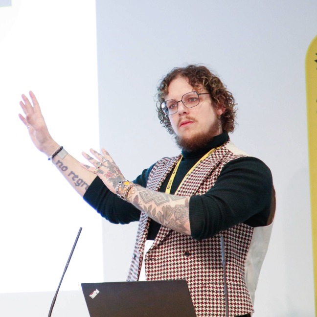 A person stands in front of a group of people presenting