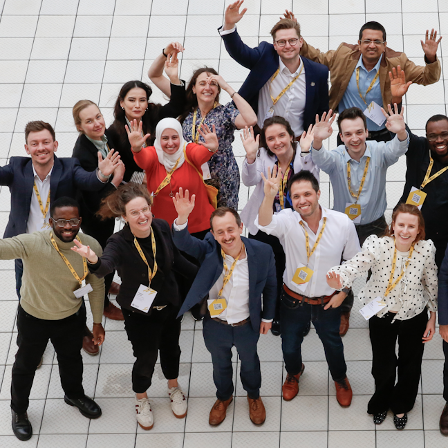 Members smile and wave up at the camera