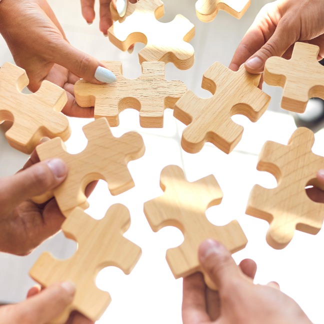 Lots of wooden puzzle pieces being connected together.
