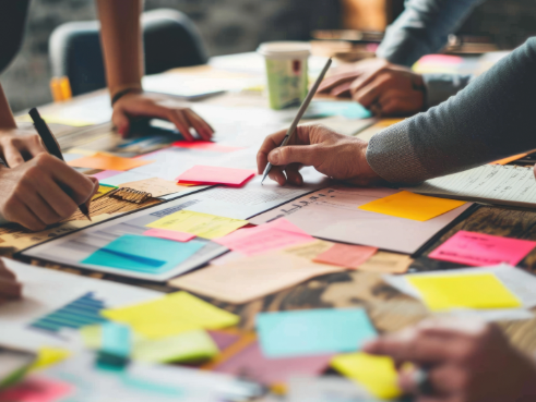 People at a workshop collaborating and drawing on sticky notes.