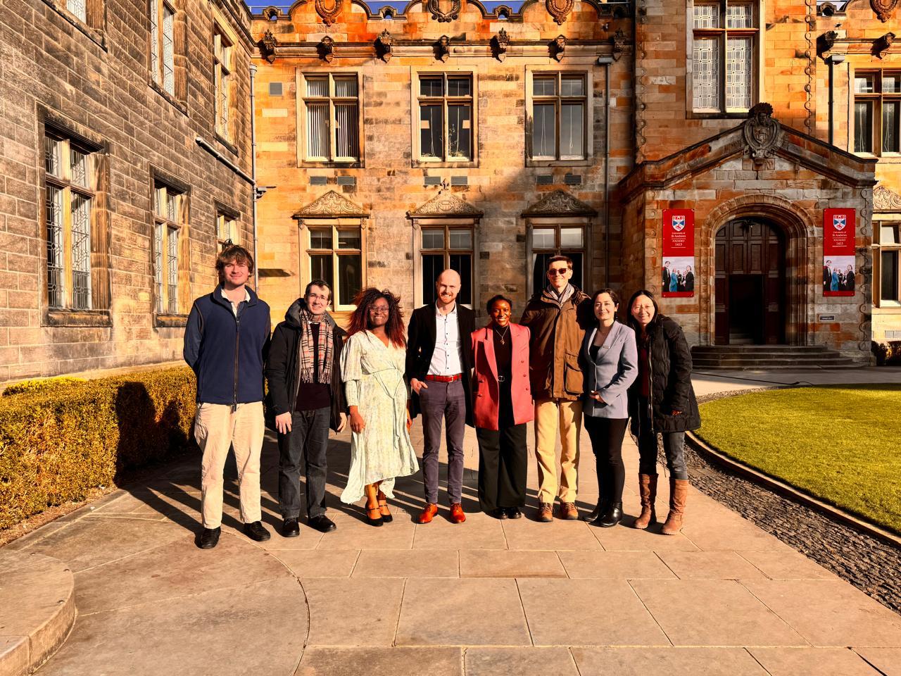 IMAGINE project team pose for a group photograph outside a historic university building with a stone façade and landscaped courtyard.